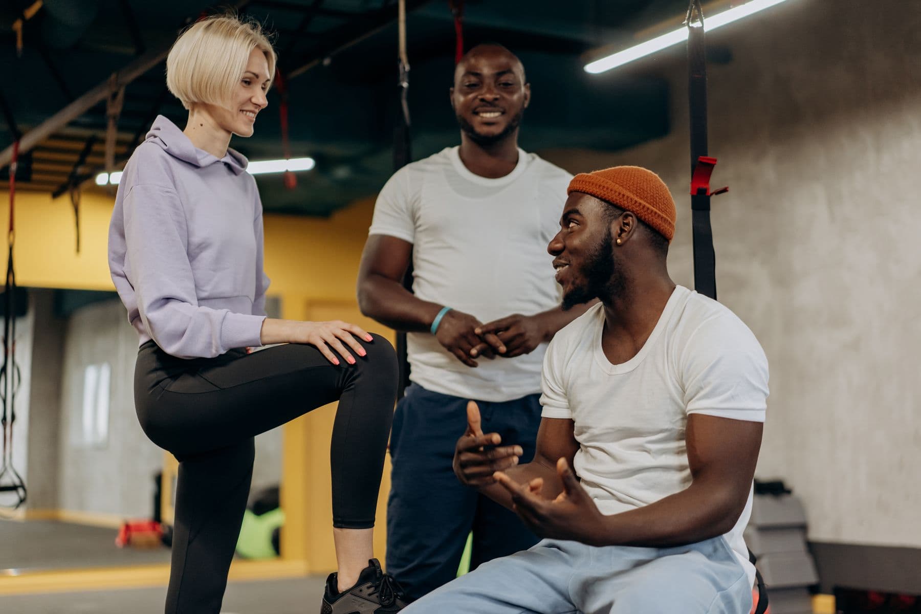 Three people connecting after training in a gym